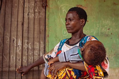 Martha Isaac, a mother and farmer from Nigeria, with her child